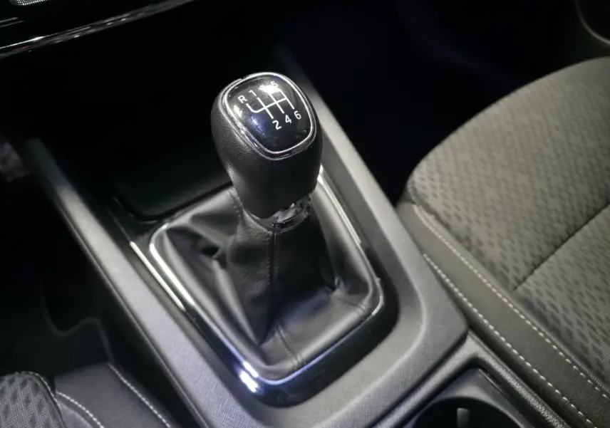 Le levier de vitesses manuel noir de la Skoda Octavia 2023, avec sellerie tissu grise visible en gros plan intérieur.