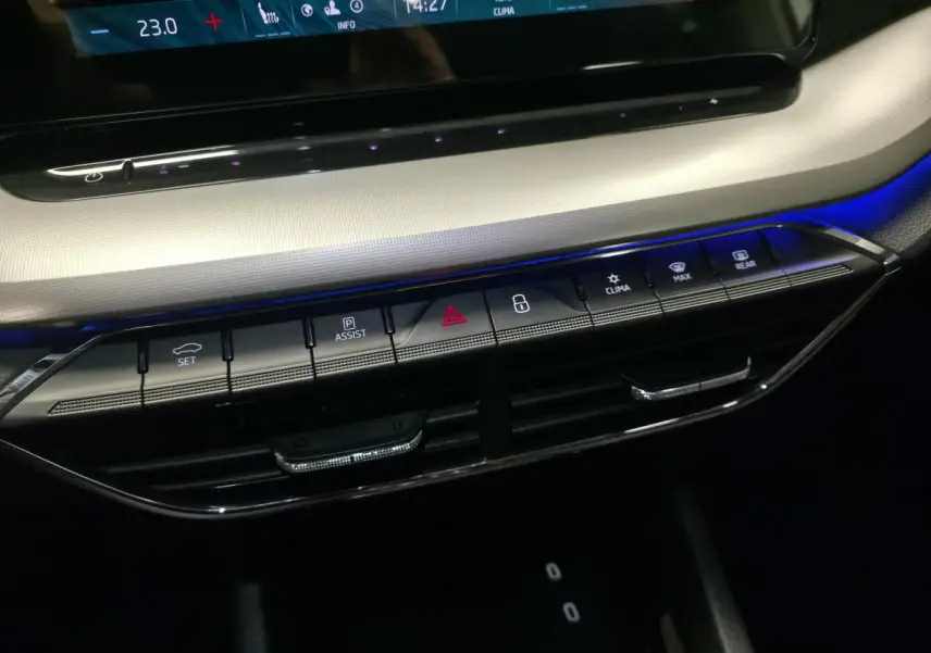 Gros plan sur la console centrale de la Skoda Octavia 2023 avec boutons de commande et éclairage d'ambiance bleu.