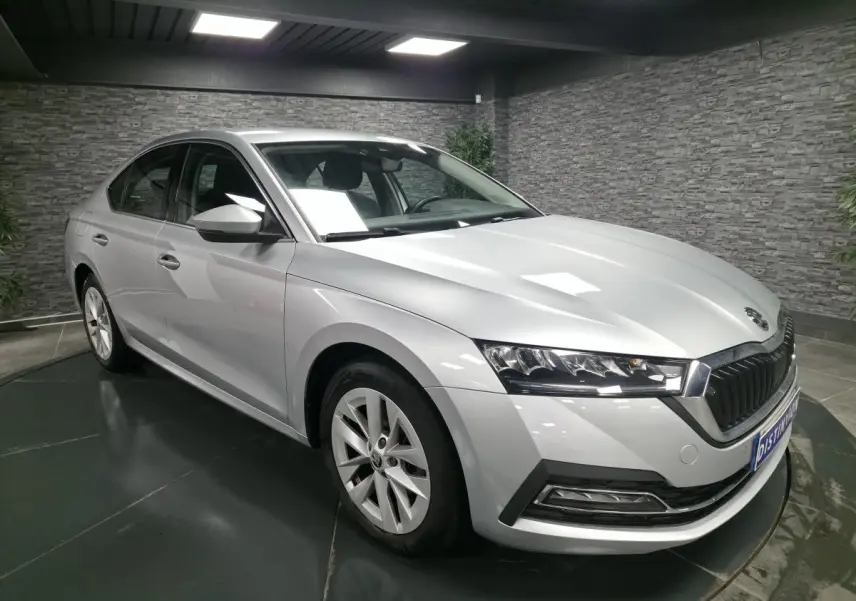 Vue 3/4 avant d'une Skoda Octavia gris métallisé 2023 avec jantes alliage 17 pouces dans un showroom intérieur.