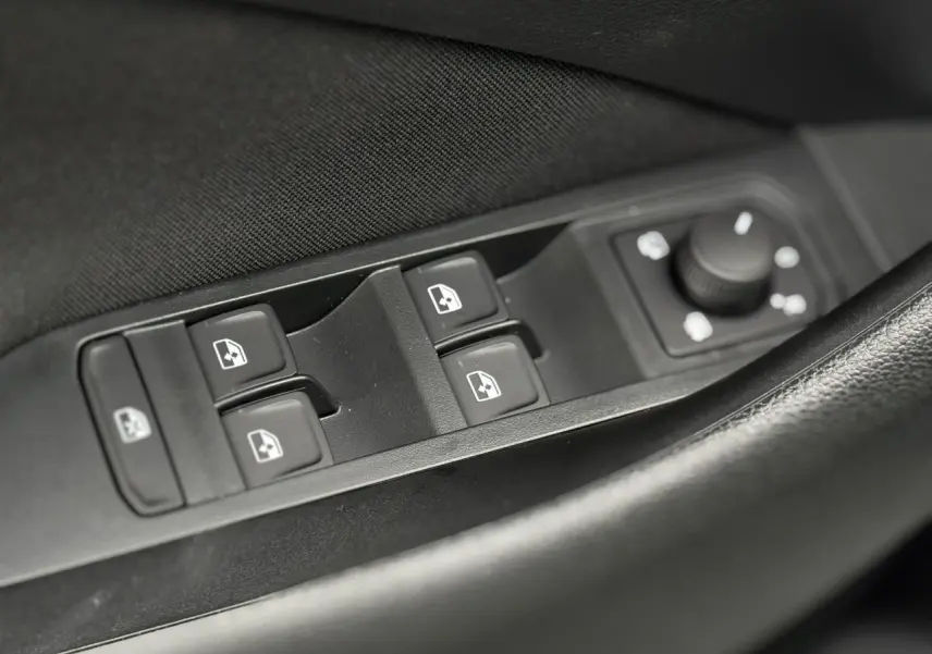 Gros plan sur les commandes des vitres et rétroviseurs côté conducteur du Skoda Kamiq gris argent 2025.