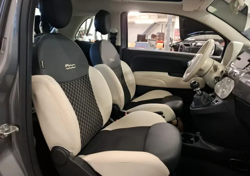 Vue intérieure côté gauche de la FIAT 500 2022 gris Electroclash, sièges bicolores avec logo 500 brodé sur appuie-tête.