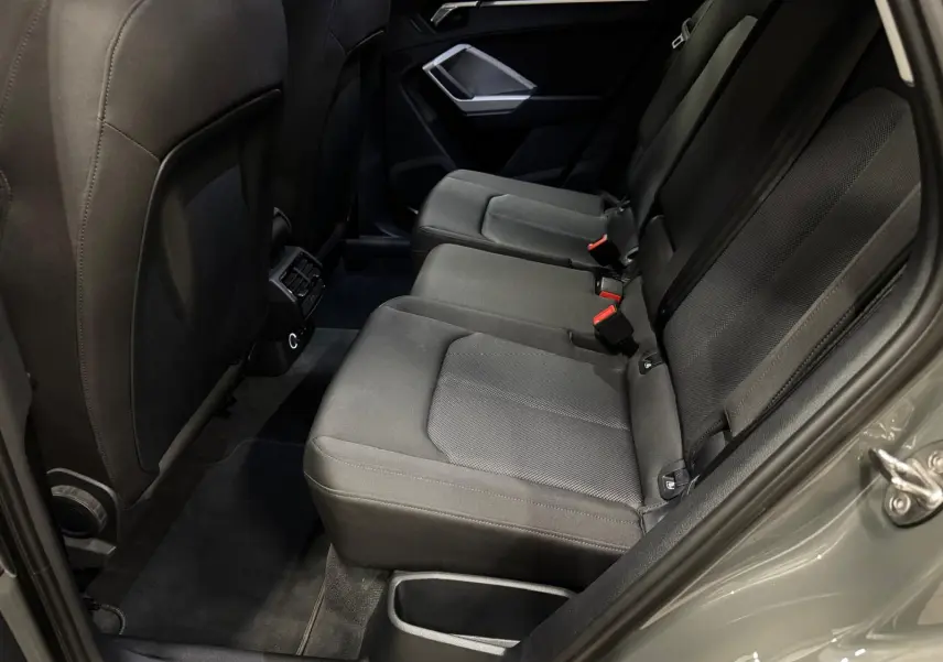 Vue côté droit de la banquette arrière en tissu gris foncé de l'Audi Q3 Business 2019 avec porte ouverte.