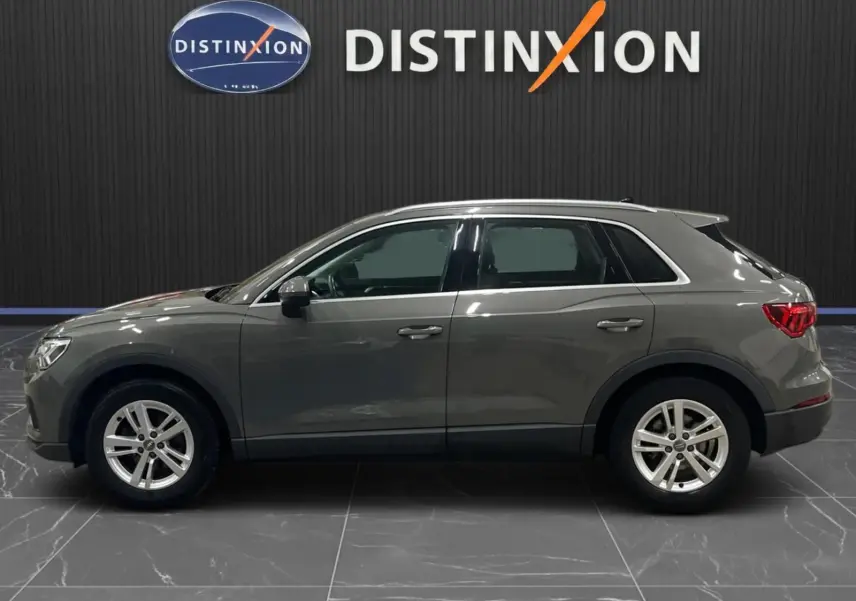 Profil droit d'un Audi Q3 Business gris 2019, mettant en valeur ses jantes alliage et feux arrière LED.