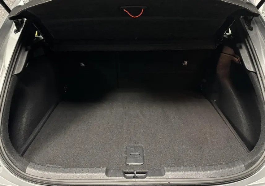 Coffre ouvert d'une Toyota Corolla hybride gris, montrant un espace de rangement propre et bien fini.