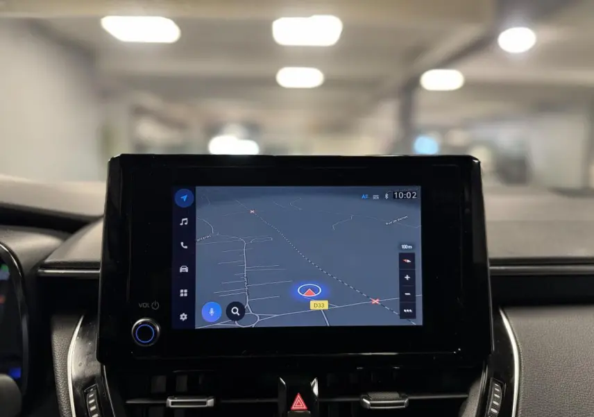 Écran tactile central affichant la navigation GPS dans l'habitacle d'une Toyota Corolla hybride gris 2022.