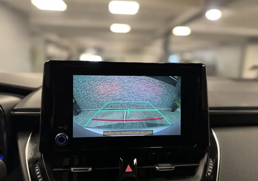 Écran central affichant la caméra de recul d'une Toyota Corolla hybride 2022, intérieur noir moderne.