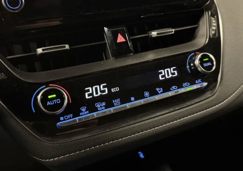 Détail de la console centrale noire laquée avec climatisation automatique bi-zone de la Toyota Corolla hybride gris 2022
