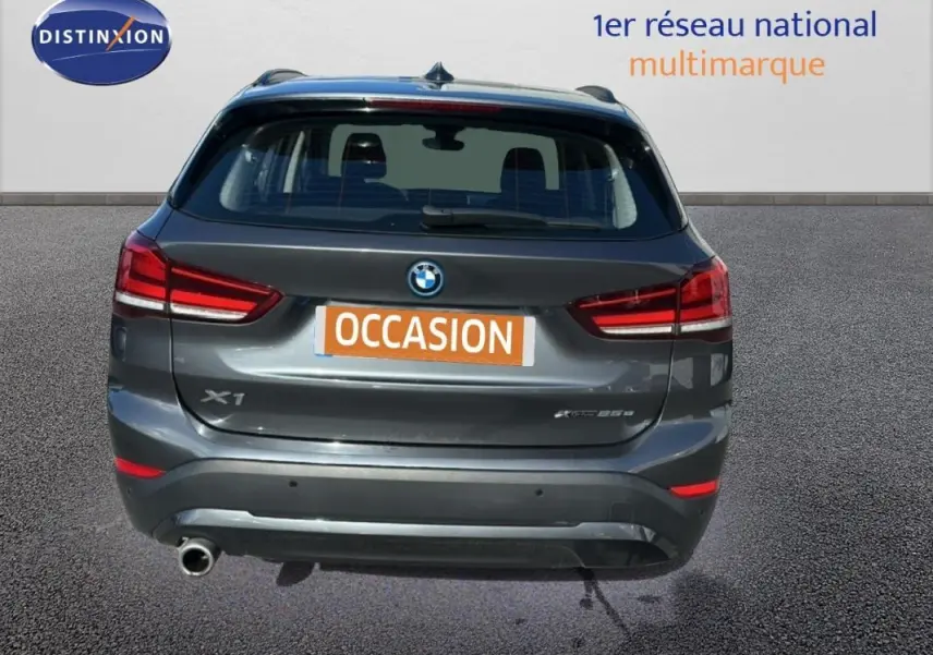 Vue arrière d’un BMW X1 gris foncé avec feux rouges et plaque d’immatriculation orange « OCCASION ».