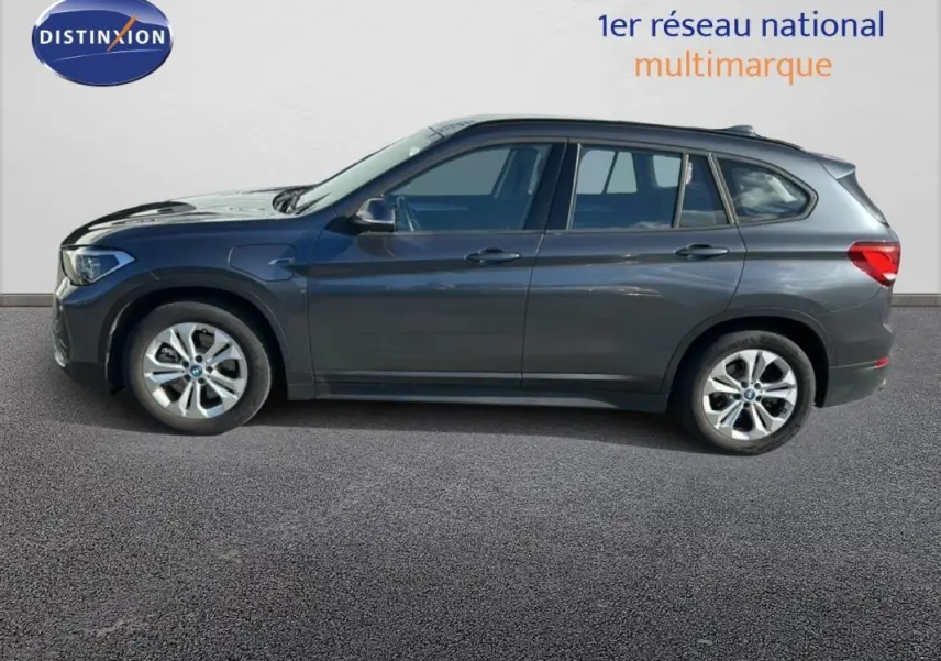 Profil côté gauche d'un BMW X1 gris foncé 2022 avec jantes alliage 18 pouces sur fond neutre.