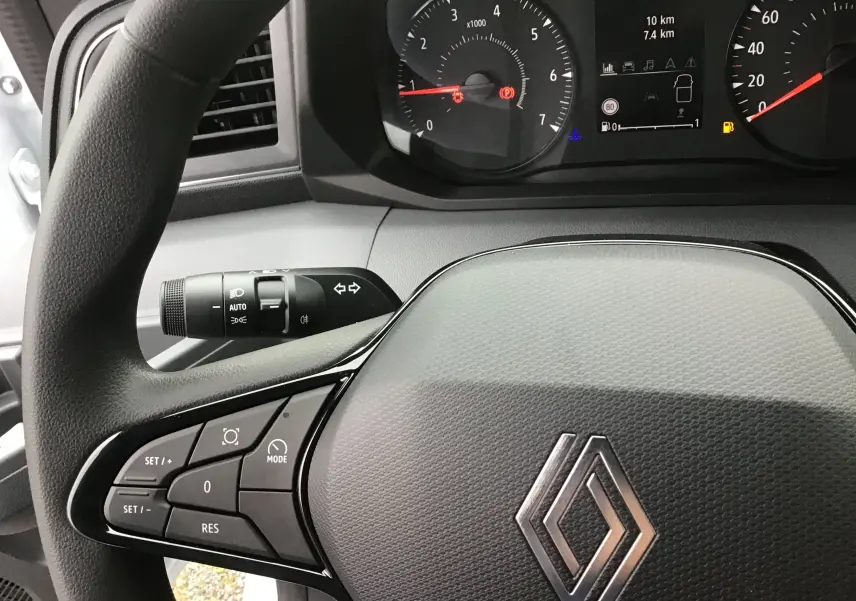 Vue rapprochée du volant noir du Renault Master 2025 avec commandes intégrées et tableau de bord digital.