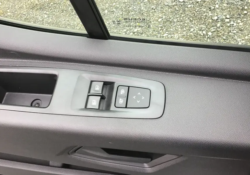 Détail des commandes de lève-vitres et réglage des rétroviseurs sur la porte côté conducteur du Renault Master blanc.