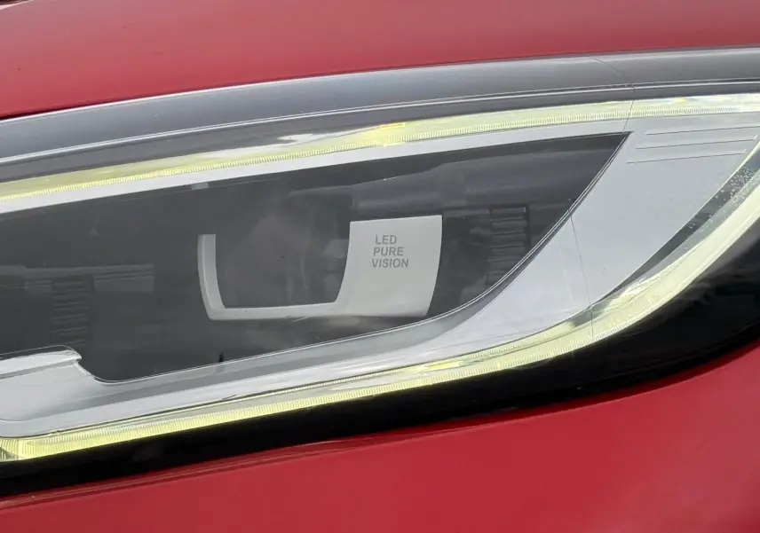 Gros plan sur le phare avant droit LED Pure Vision d’un Renault Kadjar rouge flamme de 2016.