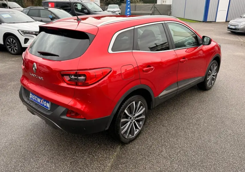 Vue 3/4 arrière droite d'un Renault Kadjar rouge flamme avec jantes alliage bi-ton et vitres teintées.