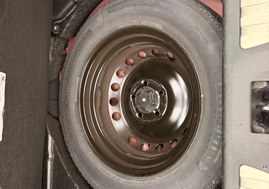 Vue rapprochée de la roue de secours noire dans le coffre d’un Renault Kadjar rouge flamme de 2016.