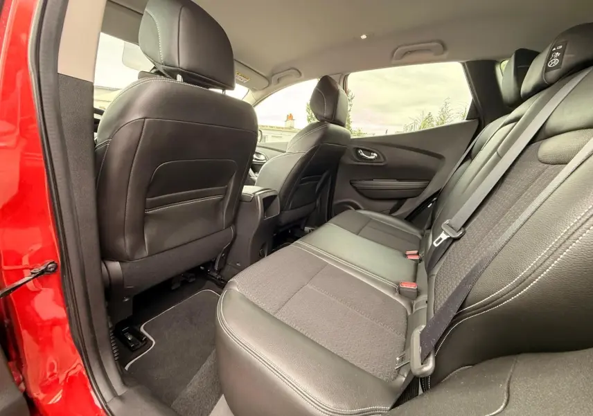 Vue intérieure arrière côté gauche du Renault Kadjar rouge flamme, sièges arrière en cuir noir et tissu gris.