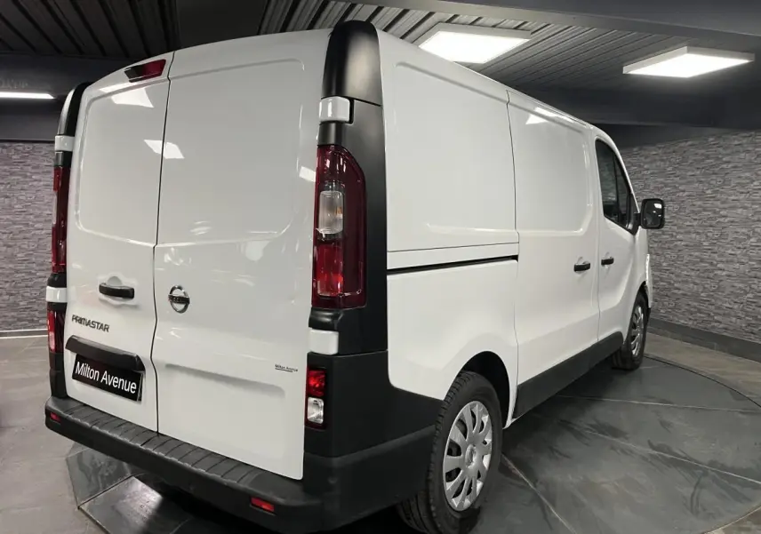 Vue 3/4 arrière droite d'un utilitaire Nissan Primastar blanc avec portes arrière tôlées et jantes acier 16 pouces.