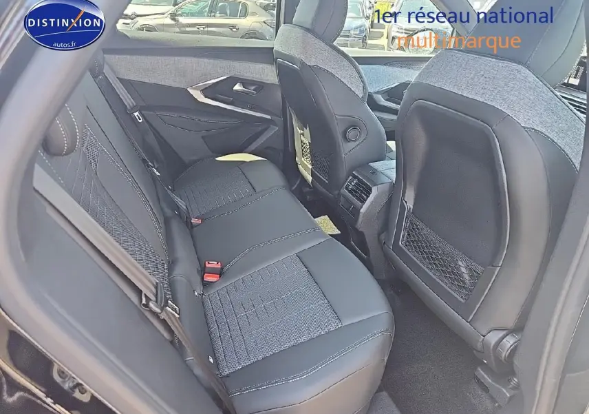 Vue intérieure arrière montrant la banquette en tissu gris et cuir noir du Peugeot 3008 hybride 2025.