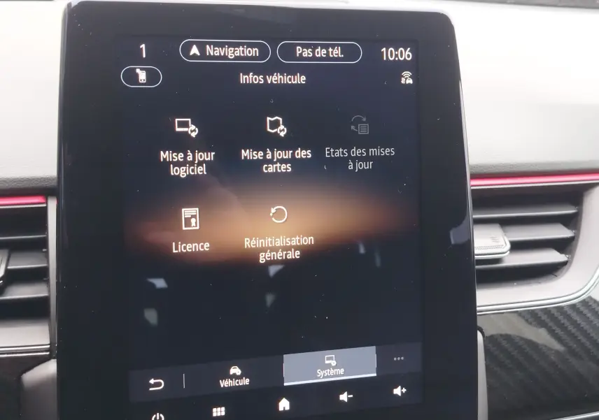 Écran tactile central du Renault Arkana 2022 affichant le menu de mise à jour logiciel et cartes, intérieur avec finition noire et rouge.