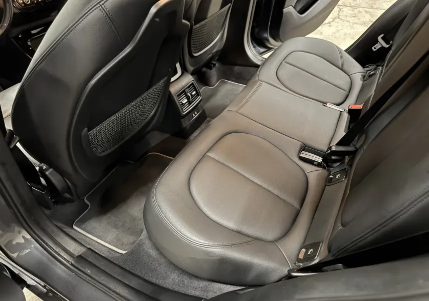 Vue intérieure arrière côté droit du BMW X2 2019, sièges cuir noir et tapis de sol velours gris.