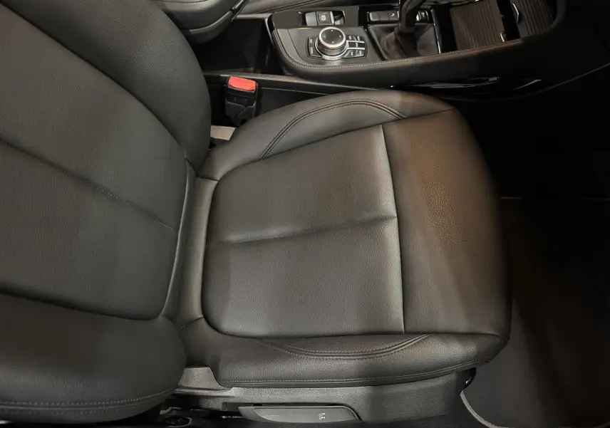 Gros plan sur le siège conducteur en cuir noir et la console centrale avec commandes du BMW X2 gris Minéral Métallique.