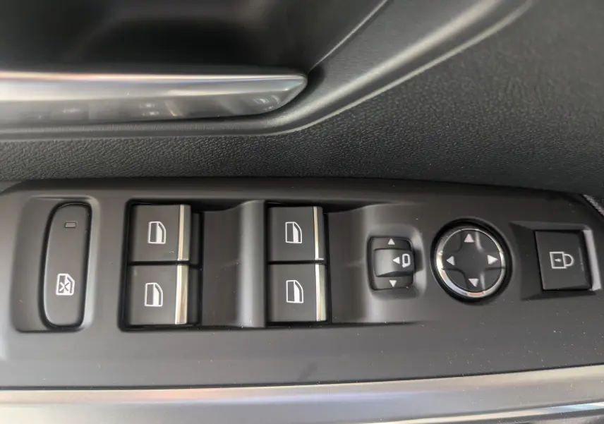 Gros plan sur les commandes de lève-vitres et rétroviseurs côté conducteur du Peugeot 3008 Hybrid 2026, finition noire.
