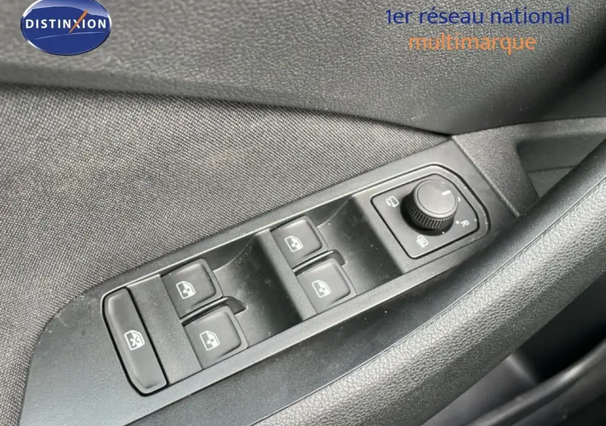 Gros plan sur les commandes des vitres électriques et réglage des rétroviseurs côté conducteur d’une Skoda Scala blanc glacier.