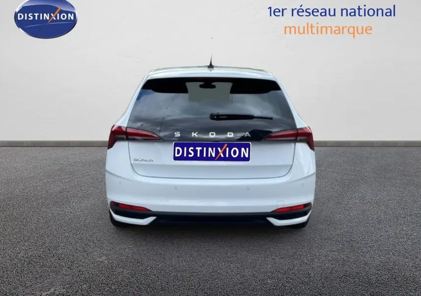 Vue arrière d'une Skoda Scala blanc glacier avec feux arrière étirés et vitre arrière teintée.