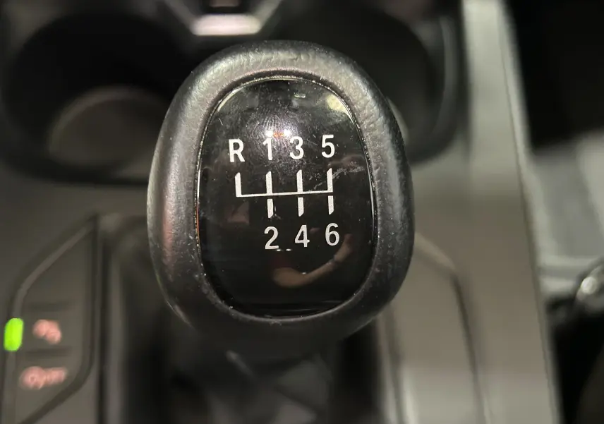 Gros plan sur le levier de vitesses manuel noir de la BMW Série 1 16d 116ch, montrant la grille des 6 rapports et la marche arrière.