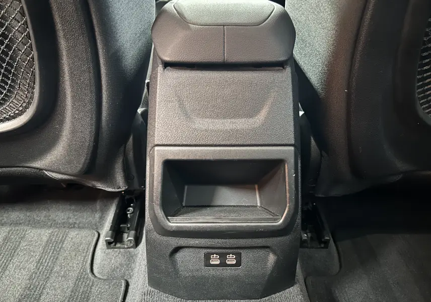 Vue rapprochée de la console centrale arrière noire de la BMW Série 1 16d 2023 avec ports USB visibles.