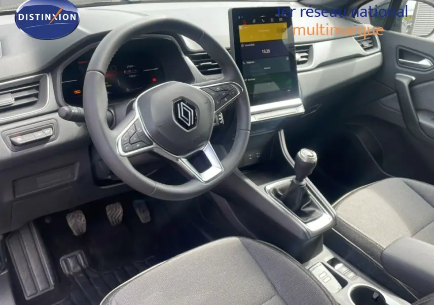 Vue intérieure côté conducteur du Renault Captur 2025, volant multifonction, boîte manuelle et écran tactile central.