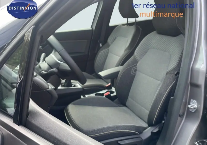 Vue intérieure côté conducteur du Renault Captur gris Cassiopée avec sièges tissu gris et volant multifonction.