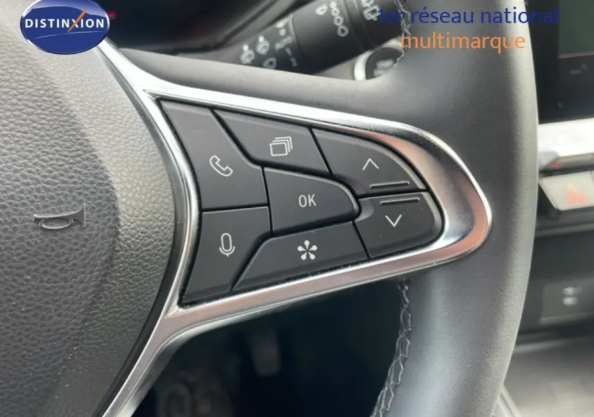 Gros plan sur les commandes multifonctions à droite du volant cuir noir du Renault Captur gris cassiopée métal.