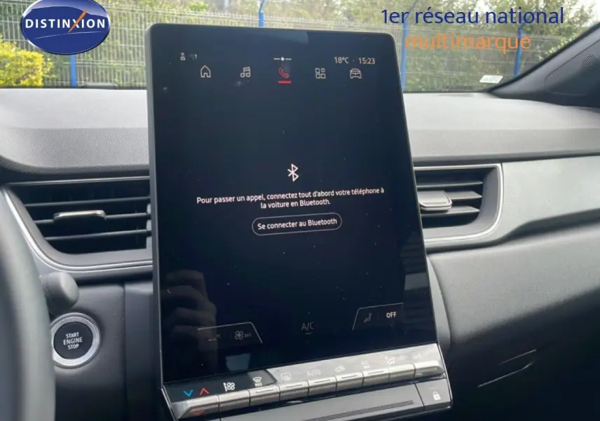 Vue intérieure du tableau de bord du Renault Captur 2025, écran tactile central avec interface Bluetooth, finition gris cassiopée métal.
