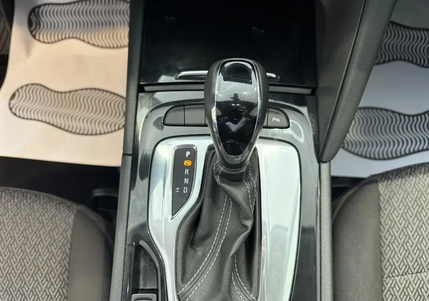 Coffre ouvert vu de l'arrière d'une Opel Insignia Sports Tourer bleu marine, montrant un espace de chargement spacieux et propre.