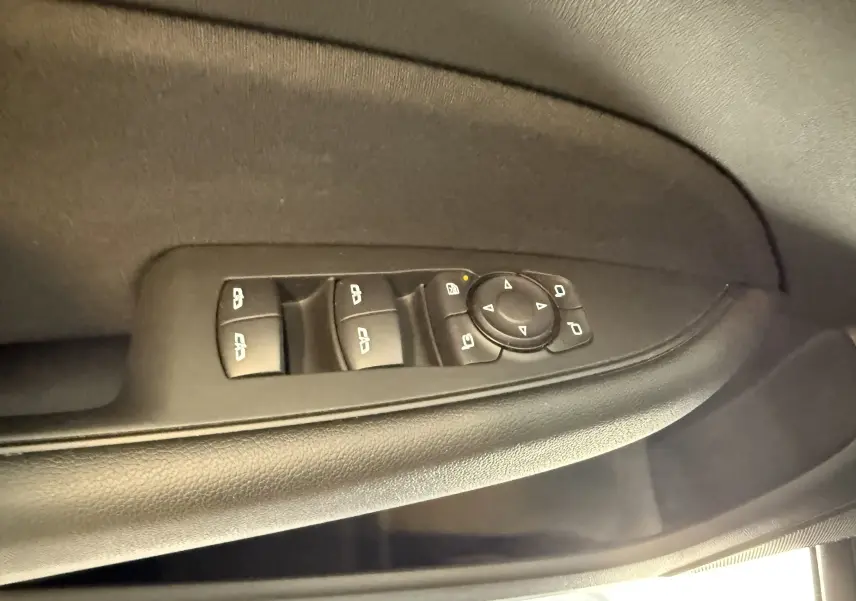 Commande des vitres électriques et réglage des rétroviseurs sur la porte côté gauche d'une Opel Insignia Sports Tourer bleu marine.