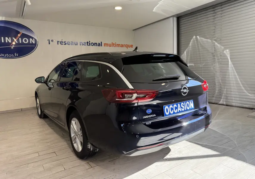 Opel Insignia Sports Tourer bleu lune marine métal vue 3/4 arrière droit en intérieur avec plaque occasion.