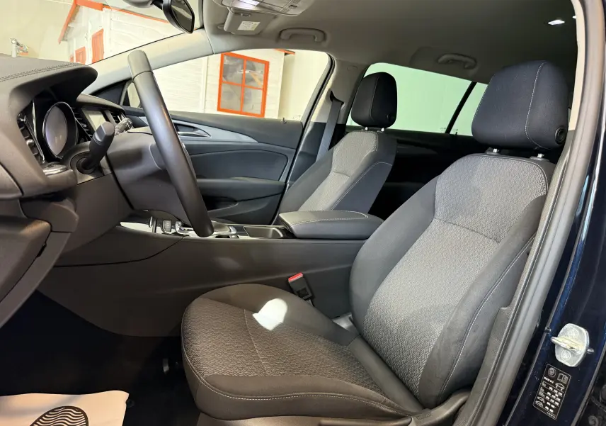 Tableau de bord de l'Opel Insignia Sports Tourer 2019, affichage digital central et compteurs analogiques éclairés.