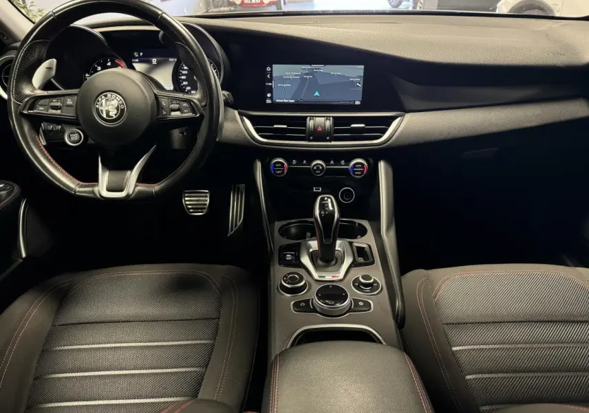 Intérieur noir de l'Alfa Romeo Giulia 2.2 D 190 2021, vue centrale sur tableau de bord et volant cuir.
