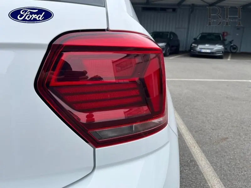 Gros plan sur le feu arrière droit d'une Volkswagen Polo blanche, soulignant ses lignes angulaires et son design moderne.