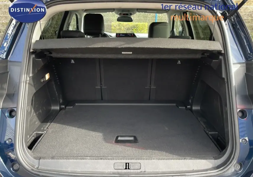 Coffre ouvert d’un Citroën C5 Aircross bleu Eclipse Metal, vue arrière montrant l’espace de chargement vide et la tablette arrière.