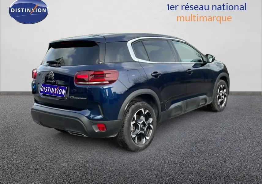 Vue 3/4 arrière droite d'un Citroën C5 Aircross 2024 bleu Eclipse Métal avec jantes alliage et vitres teintées.