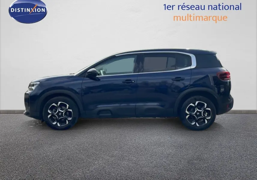 Vue de profil côté gauche d'un Citroën C5 Aircross 2024 bleu eclipse métal avec jantes alliage distinctives.