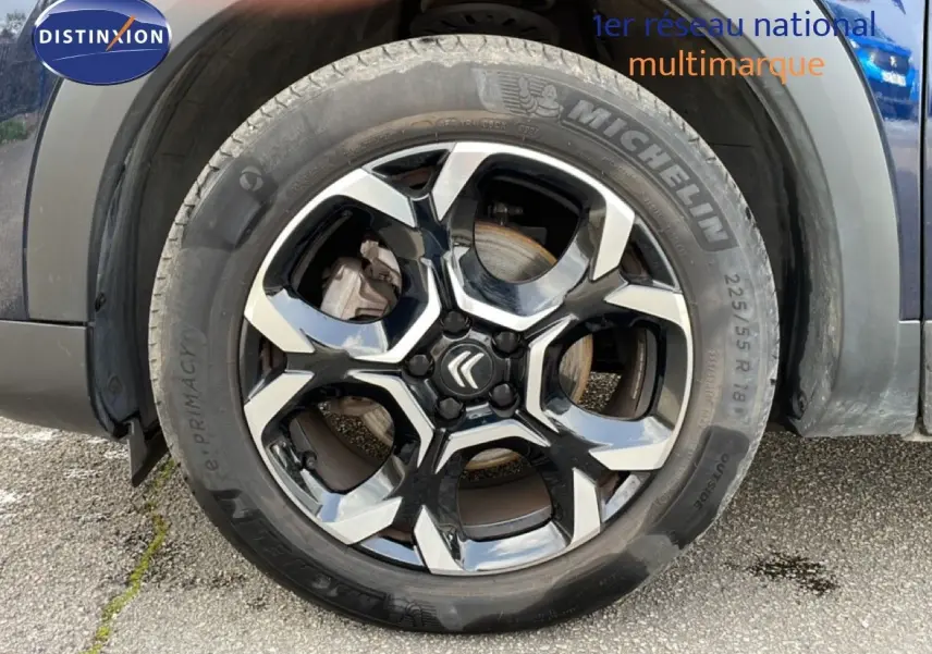 Gros plan sur la roue avant droite avec jante noire et argentée du Citroën C5 Aircross bleu Eclipse Metal 2024.