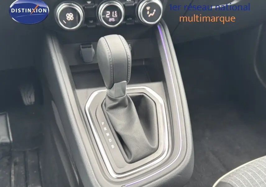 Gros plan sur la console centrale de la Renault Clio 2025, boîte automatique, avec levier en cuir noir et commandes de climatisation.