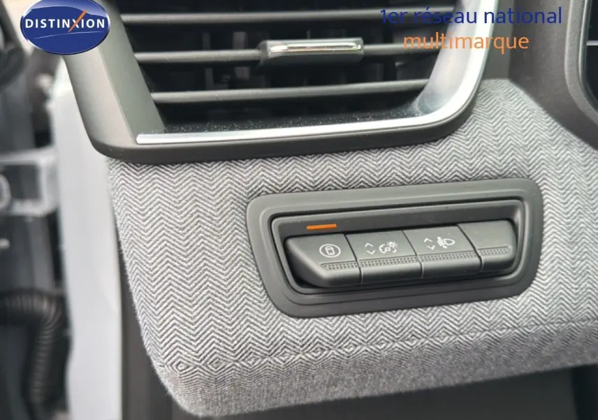 Détail du tableau de bord de la Renault Clio 2025, bouton de réglage éclairage sur habillage tissu gris à chevrons.