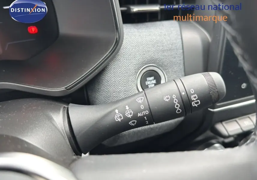 Gros plan sur la commande d'essuie-glace à gauche du volant dans l'habitacle gris noir de la Renault Clio 2025.