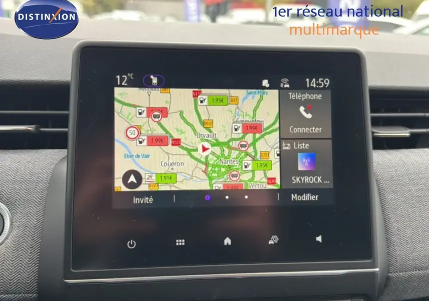 Vue rapprochée de l’écran tactile du tableau de bord de la Renault Clio gris Rafale, affichant la navigation et les options multimédia.