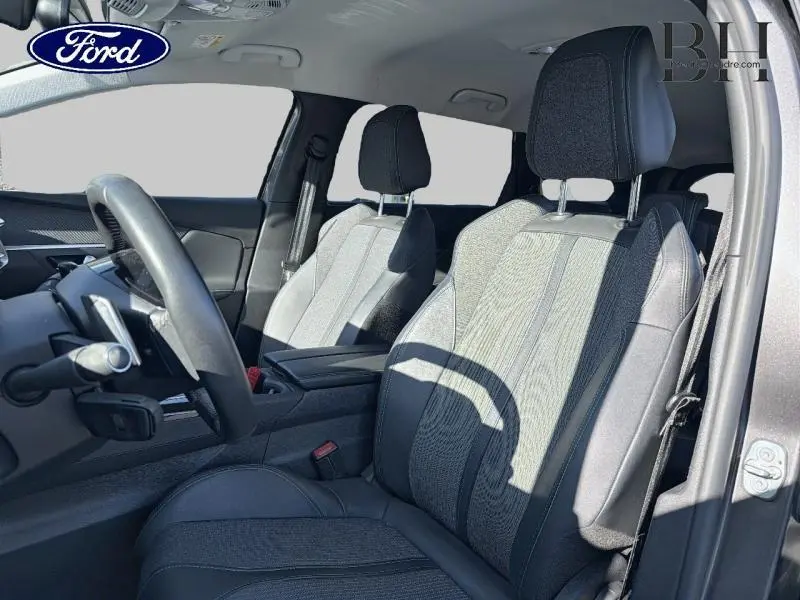 Vue intérieure côté conducteur du Peugeot 5008 gris Platinium, sièges en tissu TEP & Colyn Mistral avec volant cuir multifonction.