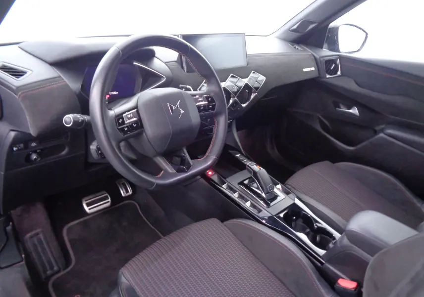 Intérieur du DS3 Crossback 2021 vu côté conducteur, tableau de bord noir avec volant multifonction et console centrale moderne.