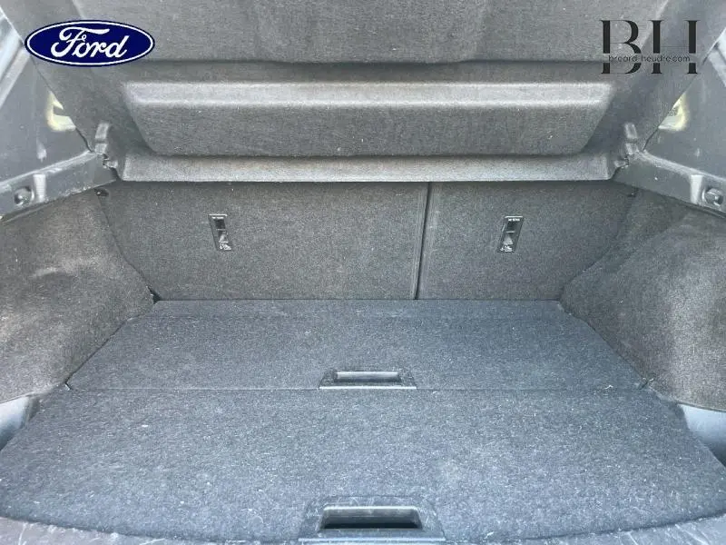 Coffre spacieux et tapissé en gris foncé du Nissan Qashqai 1.5 dCi 2019, vue intérieure arrière avec banquette rabattue.